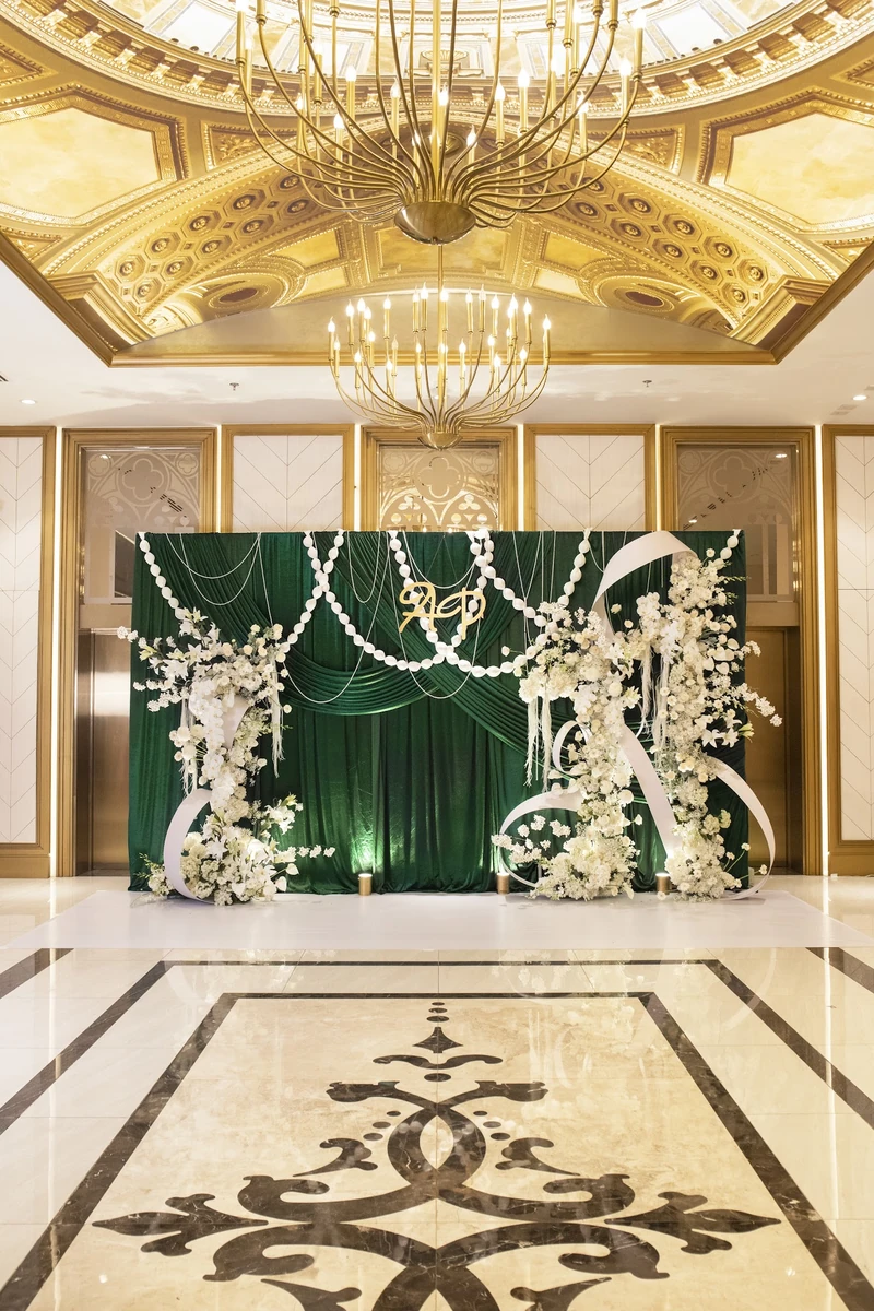Gói decor Aura chọn nền xanh lục bảo đậm làm điểm nhấn chính, mang đến vẻ sang trọng và trầm sâu cho không gian tiệc cưới